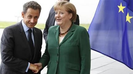Nicolas Sarkozy et Angela Merkel le 20 juillet à Berlin. La chancelière allemande est reçue mardi à Paris sous l'oeil inquiet des marchés, qui attendent des mesures audacieuses comme la mutualisation de la dette de la zone euro pour retrouver confiance en