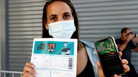Une femme à Tel-Aviv montrant son "passeport vert", un permis octroyé par les autorités israéliennes aux personnes ayant reçu deux doses du vaccin ou guéri du Covid-19 pour avoir accès à certains lieux et événements publics, 5 mars 2021 
