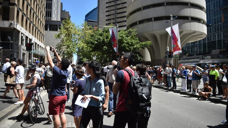 Des passants amassés devant le Café Lindt, alors qu'une prise d'otages se déroule à l'intérieur.
