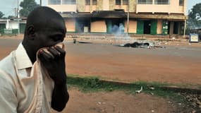Un homme se bouche le nez alors qu'il passe près d'un corps carbonisé, le 9 février, dans le centre de Bangui.