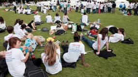 Des jeunes volontaires du service civique discutent sur la pelouse du Champs-de-mars