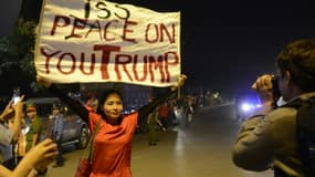 Mai Khoi, une musicienne dissidente baptisée la "Lady Gaga" du Vietnam, brandit une pancarte sur laquelle est écrit "Je te pisse dessus Trump !", le 11 novembre 2017 à Hanoi