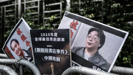 Les photos des éditeurs-libraires Lee Bo (g) et Gui Minhai déposées devant le Bureau de liaison de la Chine à Hong Kong, le 19 janvier 2016