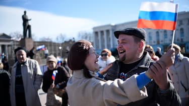 La joie au centre de Simféropol, où des prorusses exhibent un drapeau russe, après l'annonce de la demande de rattachement formulée envers la Russie par le parlement de Crimée. .