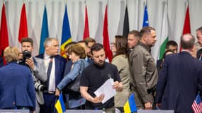Le président ukrainien Volodymyr Zelensky examine des documents alors qu'il assiste à une séance plénière du Sommet sur la paix en Ukraine.