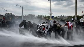 La police fait usage d'un canon à eau contre des manifestants pendant des heurts, le 1er mai 2023 à Lyon