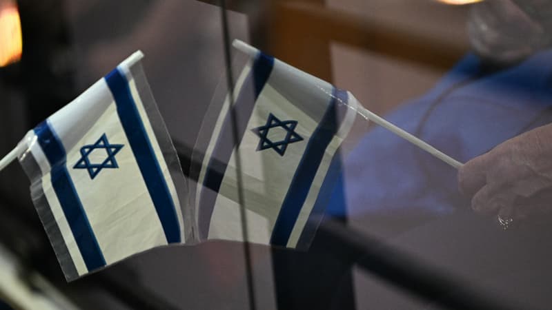 Un drapeau israélien se reflète dans une fenêtre lors d'un rassemblement de solidarité avec Israël à la synagogue de l'Espace du Judaïsme (centre culturel juif) à Toulouse, le 11 octobre 2023.