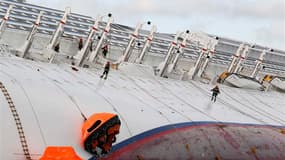 Pompiers à l'oeuvre sur le Costa Concordia. Le commandant du Costa Concordia, qui a fait naufrage le 13 janvier au large de la Toscane, a affirmé aux enquêteurs que c'est la compagnie Costa Croisières qui lui avait demandé de s'approcher le plus possible