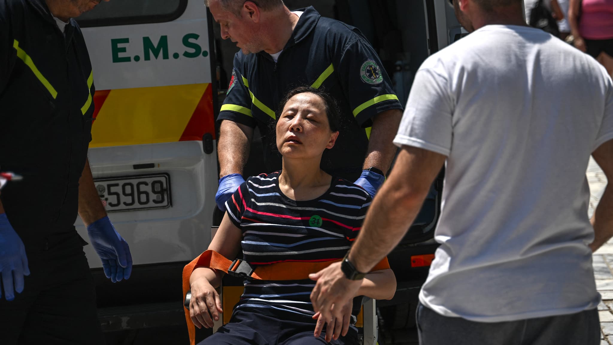 Une femme évacuée par les secours de l'Acropole, à Athènes, en raison d'une canicule, en Grèce, le 13 juillet 2023