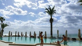 Des touristes à la piscine d'un hôtel dans la ville balnéaire de Hammamet en Tunisie, le 7 octobre 2021