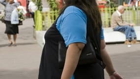 En Amérique latine -ici, une femme dans une rue de Mexico-, 58% de la population est en surpoids, principalement à cause d'une mauvaise alimentation chez les femmes et les enfants, selon un rapport de l'OMS et de la FAO