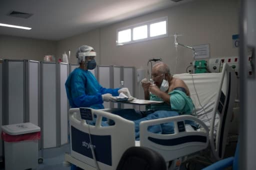 Un infirmière apporte un plateau à un malade du Covid dans un hôpital de Marica City, dans l'état de Rioo au Brésil, le 5 juin 2020. Un infirmière apporte un plateau à un malade du Covid dans un hôpital de Marica City, dans l'état de Rioo au Brésil, le 5 juin 2020.