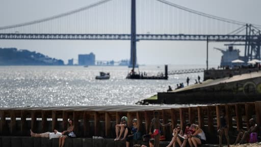 Des touristes se mettent à l'ombre sur une plage de Lisbonne, pendant un épisode de canicule, le 3 août 2018 au Portugal