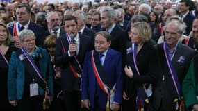 Plusieurs maires dont le président de l'AMF (Association des maires de France) David Lisnard arborant une écharpe tricolore et noire, le 19 juin 2024 à Paris.