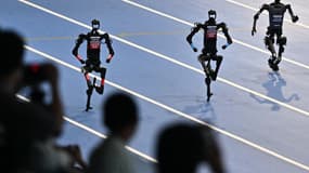 Des robots s'affrontent lors de la finale du 100 mètres des Jeux mondiaux de robots humanoïdes à Pékin, le 17 août 2025.