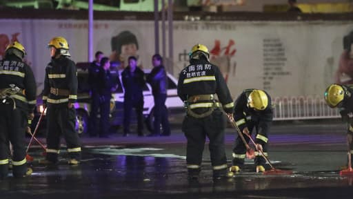 Des pompiers chinois en train de nettoyer, samedi 1er mars, le secteur où a eu lieu l'attaque "terroriste"