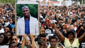 Des manifestants lèvent un portrait d'Adama Traoré en son hommage, en juillet 2018 à Beaumont-sur-Oise. -