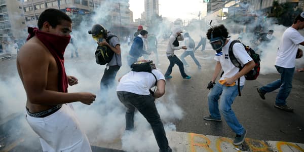 Des manifestants reçoivent du gaz lacrymogène, le 22 février, à Caracas. Des manifestants reçoivent du gaz lacrymogène, le 22 février, à Caracas.