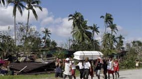 Transport d'un cercueil à New Bataan, dans la Vallée de Compostela. Les populations du sud des Philippines, balayé par le passage du typhon Bopha, ont commencé vendredi à enterrer leurs morts tandis que les secours poursuivaient les recherches. /Photo pri