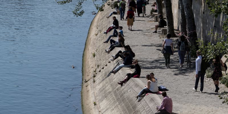 Des personnes profitant du soleil et assises sur les berges de la Seine à Paris, le 15 mai 2020. (photo d'illustration)