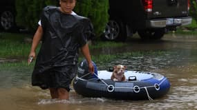 Un homme sauve son chien sur un bateau gonflable, le 29 août 2017 à Houston. 
