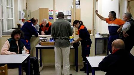 Un sans-abri (au centre) pris en charge par la Protection Civile, à Nantes. Les températures glaciales qui règnent en France dimanche contraignent, comme à Nantes, les pouvoirs publics à organiser l'hébergement d'urgence de populations précaires dont on d