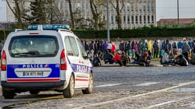 Un véhicule de police passe devant des migrants à Calais, le 21 octobre 2014.