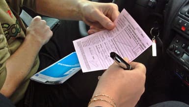 Une inspectrice remet à un élève d'une auto-école un certificat d'aptitude à la conduite après qu'il a passé avec succès l'épreuve de la conduite, à Strasbourg, le 19 avril 2002 (Photo d'illustration)