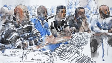 Le garde du corps de Booba est assis à la gauche du rappeur, au premier plan.