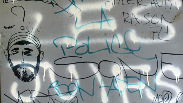 Tags antisémites et "anti-police" peints dans une cage d'escalier d'un immeuble de la cité de la Grande-Borne à Grigny, en juillet 2002