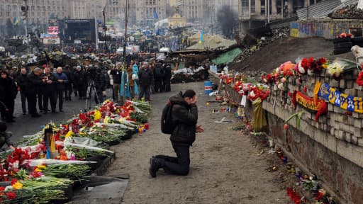 Un homme pleure devant un mémorial commémorant les manifestants tués pendant les violences en Ukraine, le 23 février 2014.