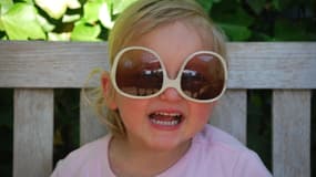 Enfant qui porte des lunettes de soleil (image d'illustration)