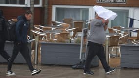 Un homme se bat avec son parapluie alors qu'il marche le long de la promenade de Blackpool le 4 août 2025 à Blackpool, Angleterre.