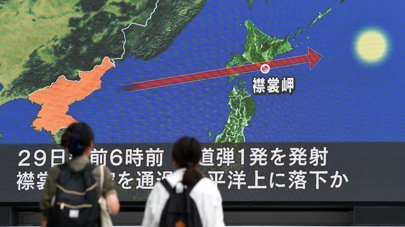Des passants à Tokyo devant un écran montrant la trajectoire du missile au-dessus du Japon le 29 août 2017