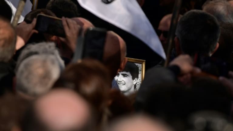 Un participant aux obsèques d'Yvan Colonna le 25 mars 2022 à Cargèse arbore un portrait du militant nationaliste mortellement blessé dans sa prison le 2 mars 2022