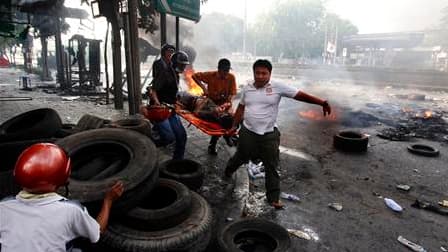 Evacuation d'un homme touché par une balle samedi à Bangkok. Selon le centre médical public Erawan, le bilan des affrontements qui opposent depuis deux jours l'armée thaïlandaise à des manifestants hostiles au gouvernement s'élève désormais à 22 morts. /P