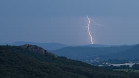 Un éclair frappe une colline au loin lors d'un orage près du Muy, dans le sud de la France, le 12 juin 2023.