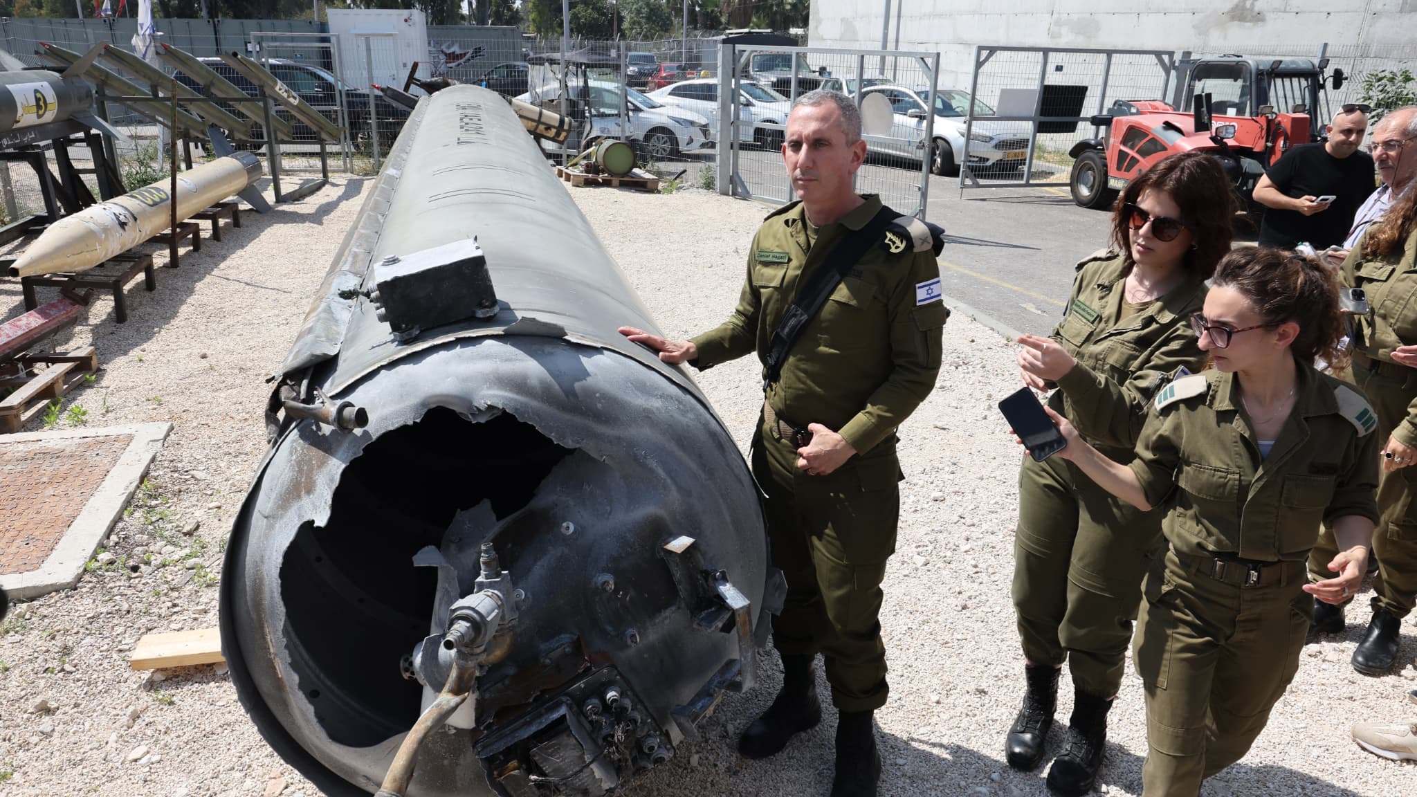 Le porte-parole de l'armée israélienne, le contre-amiral Daniel Hagari et d'autres membres de l'armée israélienne se tiennent à côté d'un missile balistique iranien tombé à la base militaire de Julis, près de la ville de Kiryat Malachi, dans le sud d'Israël, le 16 avril 2024. 