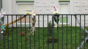 Des bouquets de fleurs sur la clôture juste devant l'appartement du rez-de-chaussée où les corps d'une femme et de ses quatre enfants ont été découverts, à Meaux, dans l'est de Paris.