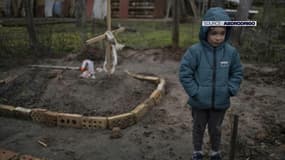 Vladi, un jeune enfant de 6 ans, devant la tombe de sa mère Marina, morte à Boutcha en mars 2022