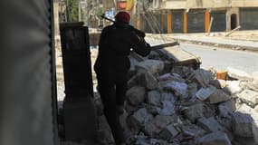 Un membre de l'Armée syrienne libre lors d'un échange de tirs avec les forces soutenant Bachar al Assad, mardi à Alep. Le président syrien a exhorté mercredi ses soldats à écraser la rébellion pour assurer l'avenir de la Syrie et de son peuple, au plus fo