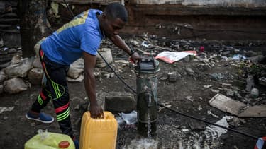Un homme rempli un jerrican d'eau à Koungou, au nord de Mayotte, le 23 mai 2023.