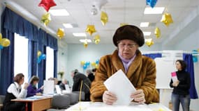 Dans un bureau de vote de Moscou. Vladimir Poutine s'imposera probablement sans difficulté dès le premier tour de l'élection présidentielle qui s'est ouvert dimanche dans l'Extrême-Orient russe, malgré les doutes de l'opposition quant à la légitimité du s