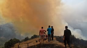 Des villageois face à un feu de forêt en Kabylie, à Tizi-Ouzou, en Algérie, le 12 août 2021