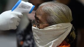 Un médecin prend la température d'une femme à Mumbai (Inde), le 10 juillet 2020.