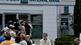 Les Grecs se pressent aux guichets des banques pour retirer de l'argent liquide. 
