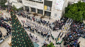 Cette vue aérienne montre des membres du mouvement scout défilant lors des célébrations de la veille de Noël sur la place de la Mangeoire, à l'extérieur de l'église de la Nativité, dans la ville biblique de Bethléem, en Cisjordanie occupée, le 24 décembre 2022.