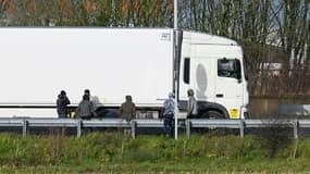Des migrants attendent de monter à l'arrière des camions à destination de la Grande-Bretagne à l'entrée du site du tunnel sous la Manche à Calais dans le Pas-de-Calais, le 17 décembre 2020.