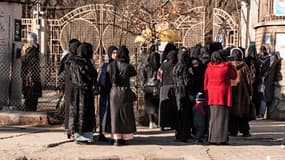 Des étudiantes afghanes devant le personnel de sécurité d'une université à Kaboul, le 21 décembre 2022