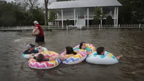 Une famille s'adaptant à la montée des eaux à Mandeville, Louisiane, lors du passage de la tempête tropicale Barry, le 13 juillet 2019